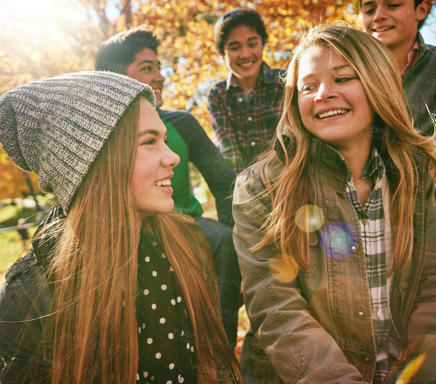 Buy stock photo Talking, happy and friends outdoor in park for relaxing day on summer vacation of semester break, together and bonding. Group, diversity and trees in garden on holiday in New Zealand and lens flare.