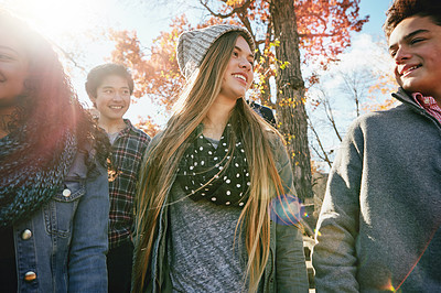 Buy stock photo Teenager, walking and talking with friends in park, nature or social group outdoor in autumn with diversity. Happy, teens or kids relax in fall with a joke, best friend or conversation in community