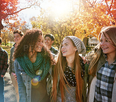 Buy stock photo Teenager, walking and talking with friends in park, nature or social group outdoor in autumn with diversity. Happy, youth or kids relax in fall with a joke, best friend or conversation in community