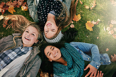 Buy stock photo Above, teenagers or girls on park for autumn, relaxing and bonding together on grass with happiness. Nature, lawn and friends on summer holiday for chilling, hanging out and laugh outdoors with smile