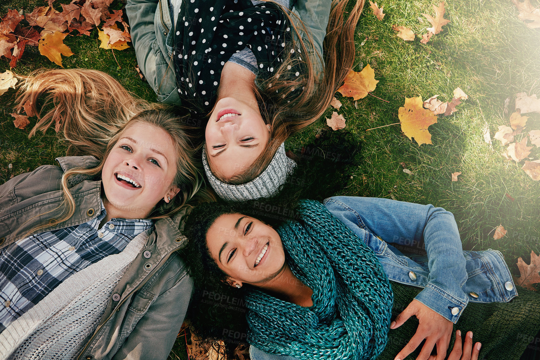 Buy stock photo Above, teenagers or girls on park for autumn, relaxing and bonding together on grass with happiness. Nature, lawn and friends on summer holiday for chilling, hanging out and laugh outdoors with smile