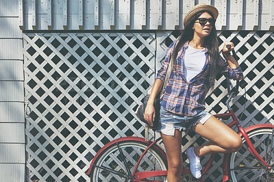 Buy stock photo Shot of a beautiful young woman riding her bike in the park