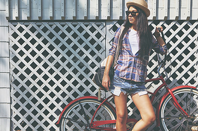 Buy stock photo Shot of a beautiful young woman riding her bike in the park