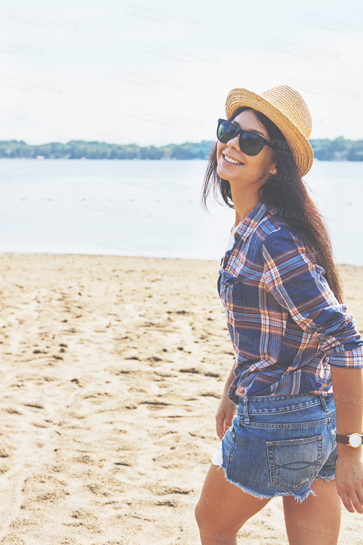 Buy stock photo Shot of an attractive young woman enjoying a day on the beach