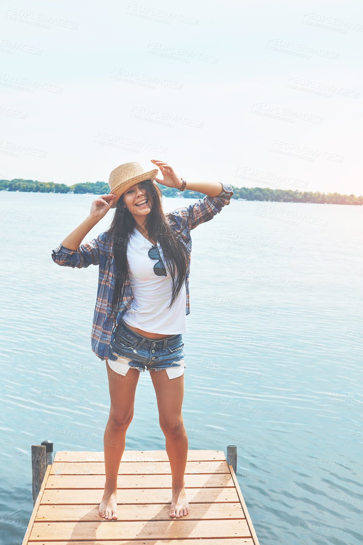 Buy stock photo Shot of an attractive young woman enjoying a day on the beach