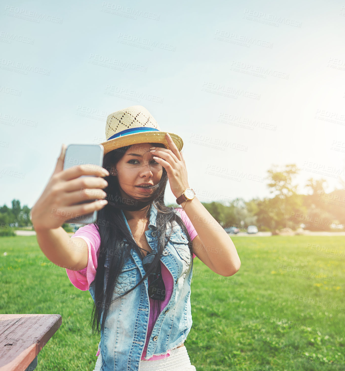 Buy stock photo Wind, girl and selfie on bench in park for profile picture on social media or memory of summer vacation in California. Woman, sunshine and holiday with photography or live blog for content creation.