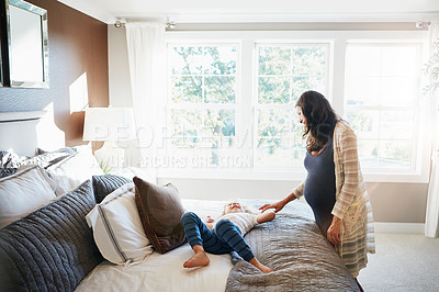 Buy stock photo Shot of a pregnant woman bonding with her little son at home