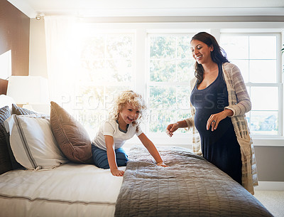 Buy stock photo Shot of a pregnant woman bonding with her little son at home