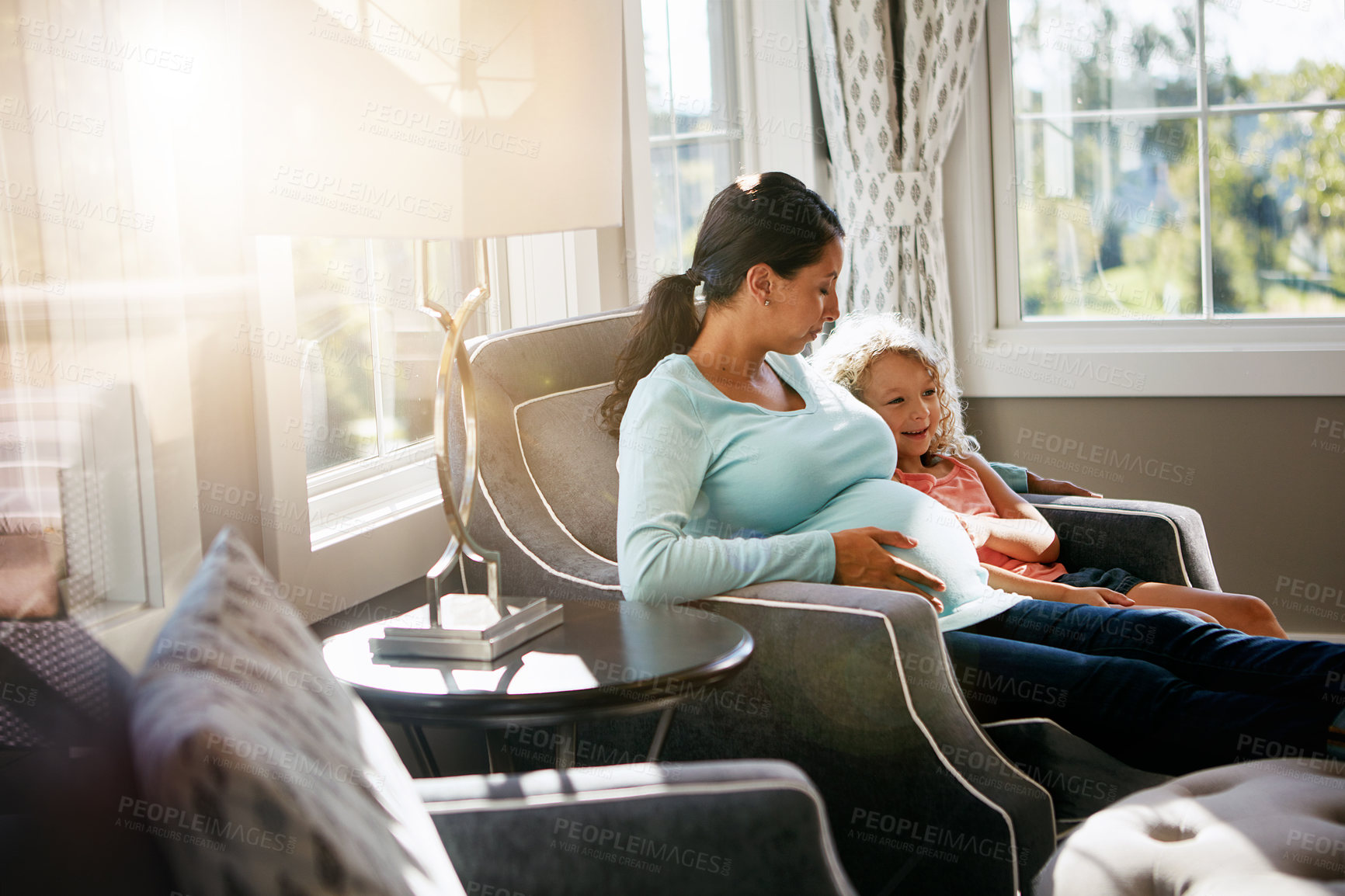 Buy stock photo Shot of a pregnant woman spending time with her daughter at home