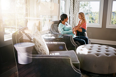 Buy stock photo Shot of a pregnant woman spending time with her daughter at home