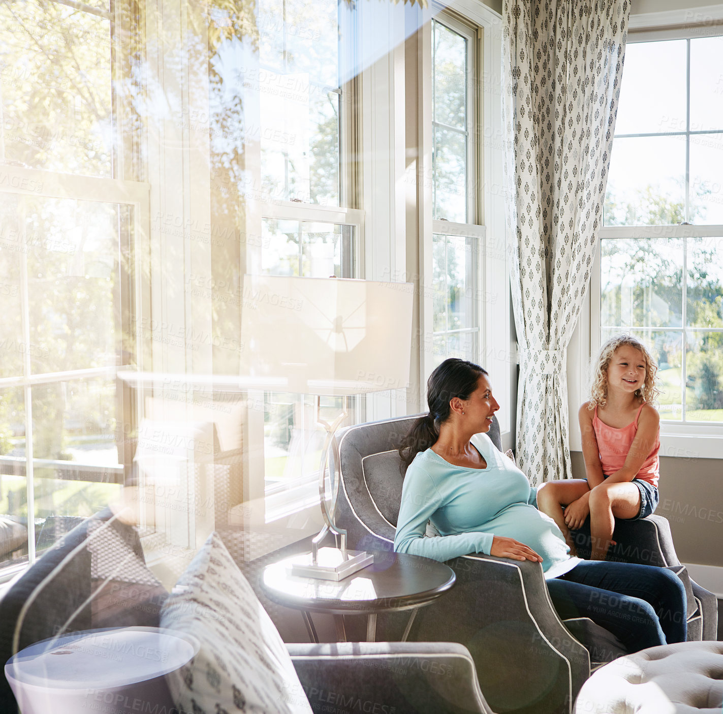 Buy stock photo Shot of a pregnant woman spending time with her daughter at home