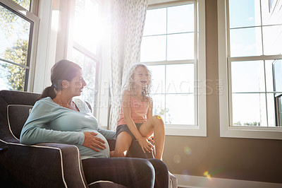 Buy stock photo Shot of a pregnant woman spending time with her daughter at home