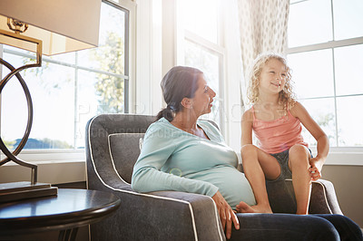 Buy stock photo Shot of a pregnant woman spending time with her daughter at home