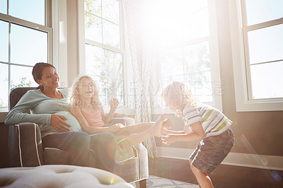 Buy stock photo Shot of a pregnant woman spending time with her children at home