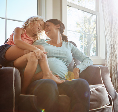 Buy stock photo Shot of a pregnant woman spending time with her daughter at home