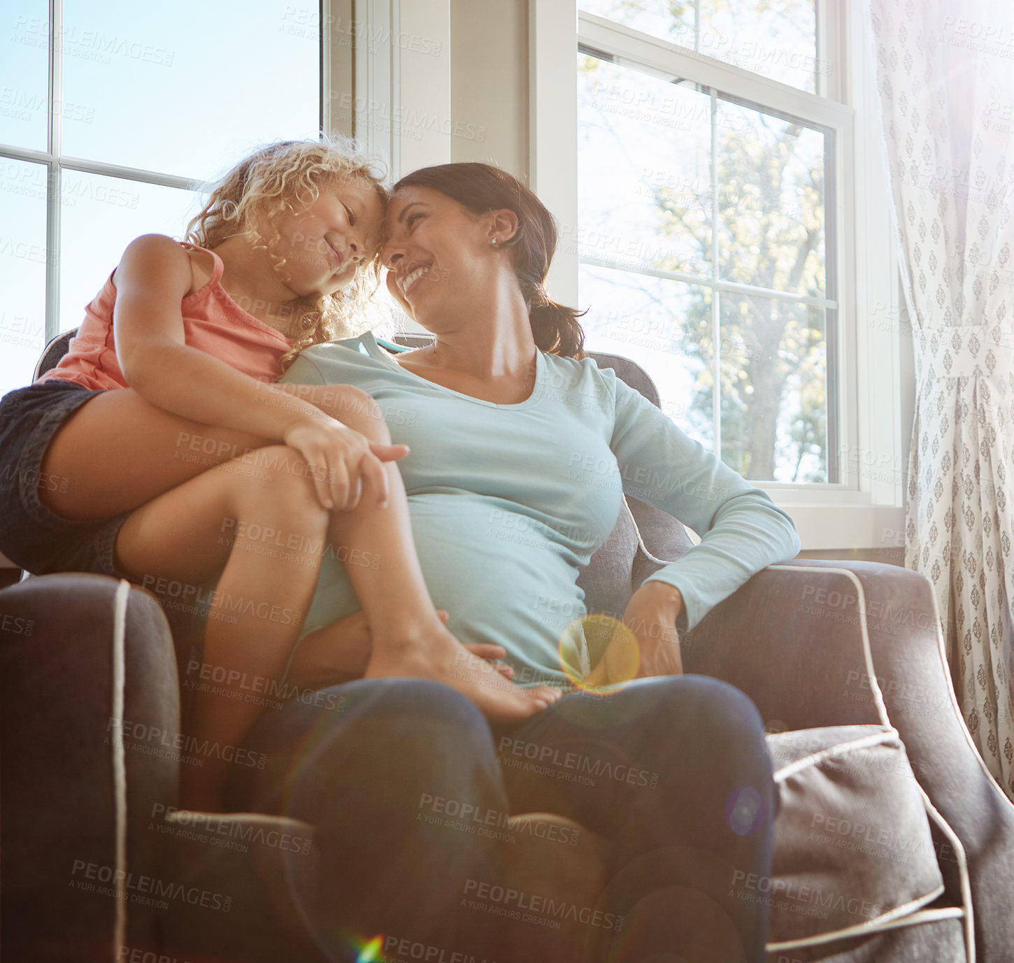 Buy stock photo Shot of a pregnant woman spending time with her daughter at home