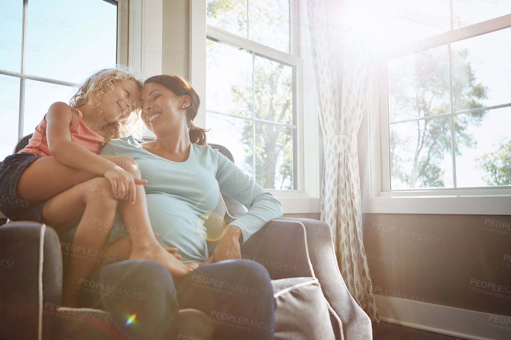 Buy stock photo Shot of a pregnant woman spending time with her daughter at home