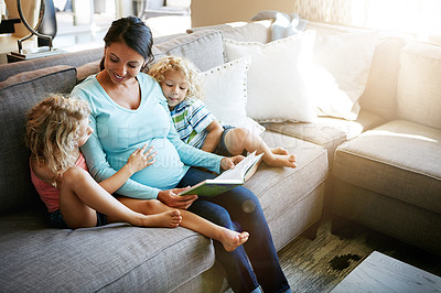 Buy stock photo Shot of a pregnant woman spending time with her children at home