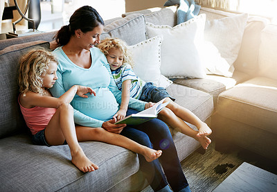 Buy stock photo Shot of a pregnant woman spending time with her children at home