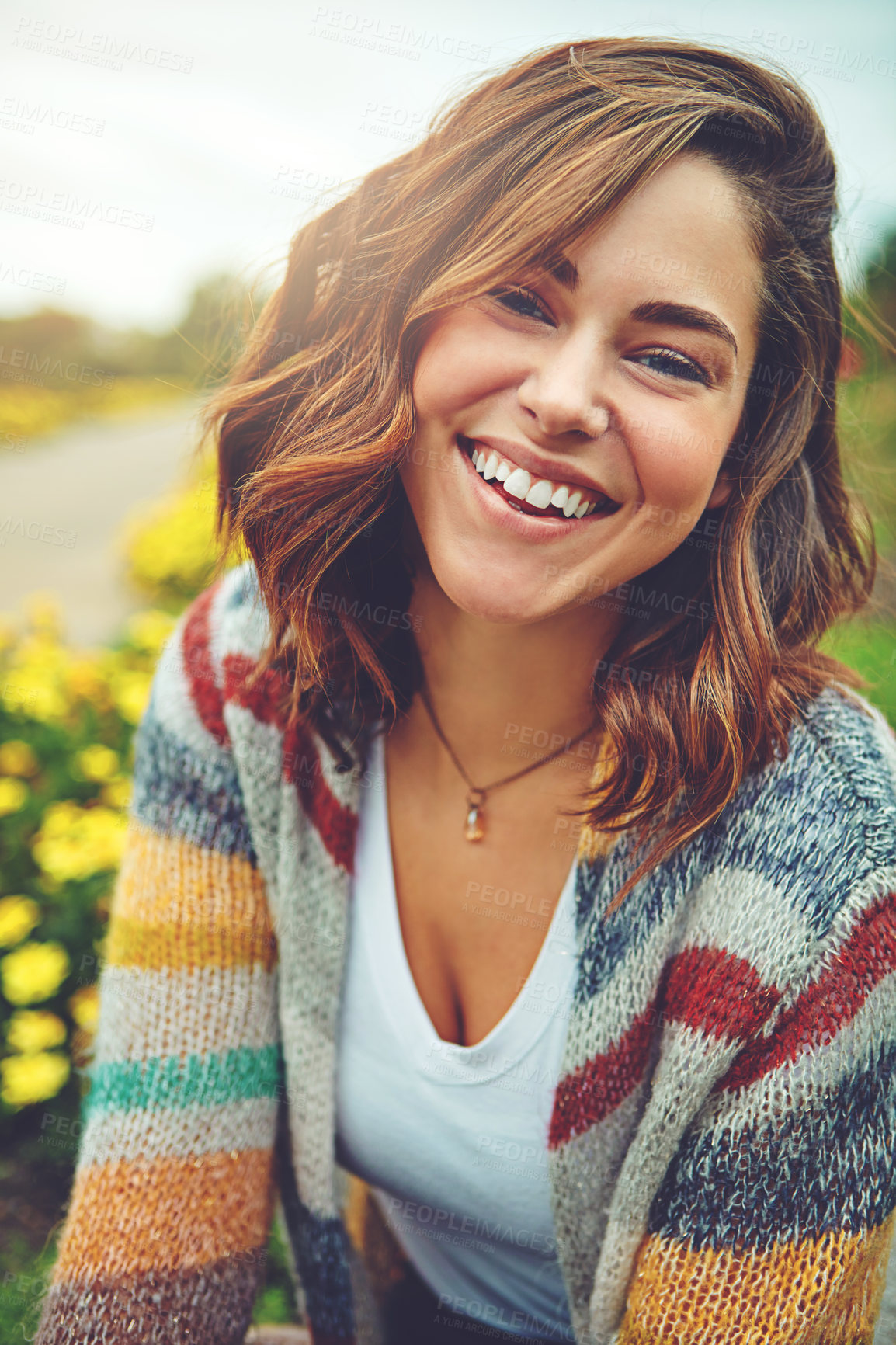 Buy stock photo Woman, portrait and flowers with smile on field or autumn environment, countryside or outdoor. Female person, face and floral daisies in sunshine with happiness for England trip, meadow or holiday