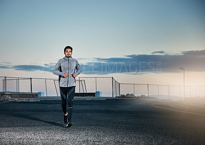 Buy stock photo Shot of a sporty young man out for a run