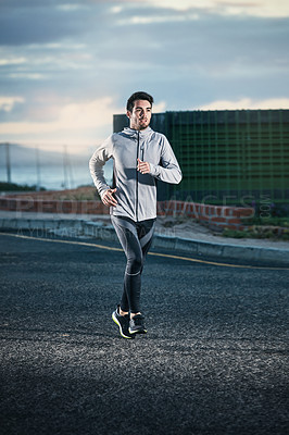 Buy stock photo Shot of a sporty young man out for a run