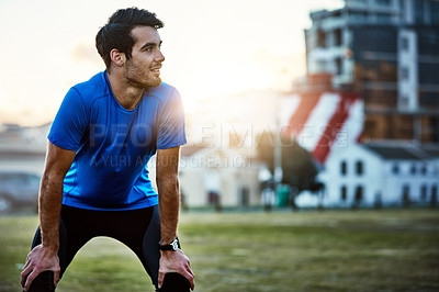 Buy stock photo Shot of a handsome young man exercising outdoors