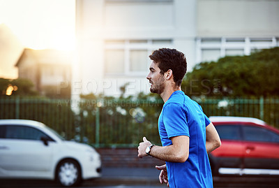 Buy stock photo Shot of a sporty young man out for a run