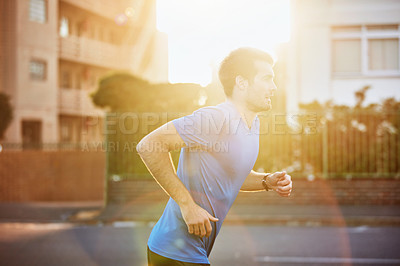 Buy stock photo Shot of a sporty young man out for a run