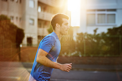 Buy stock photo Shot of a sporty young man out for a run