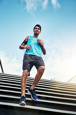 Buy stock photo Low angle shot of a handsome young man working out in the city