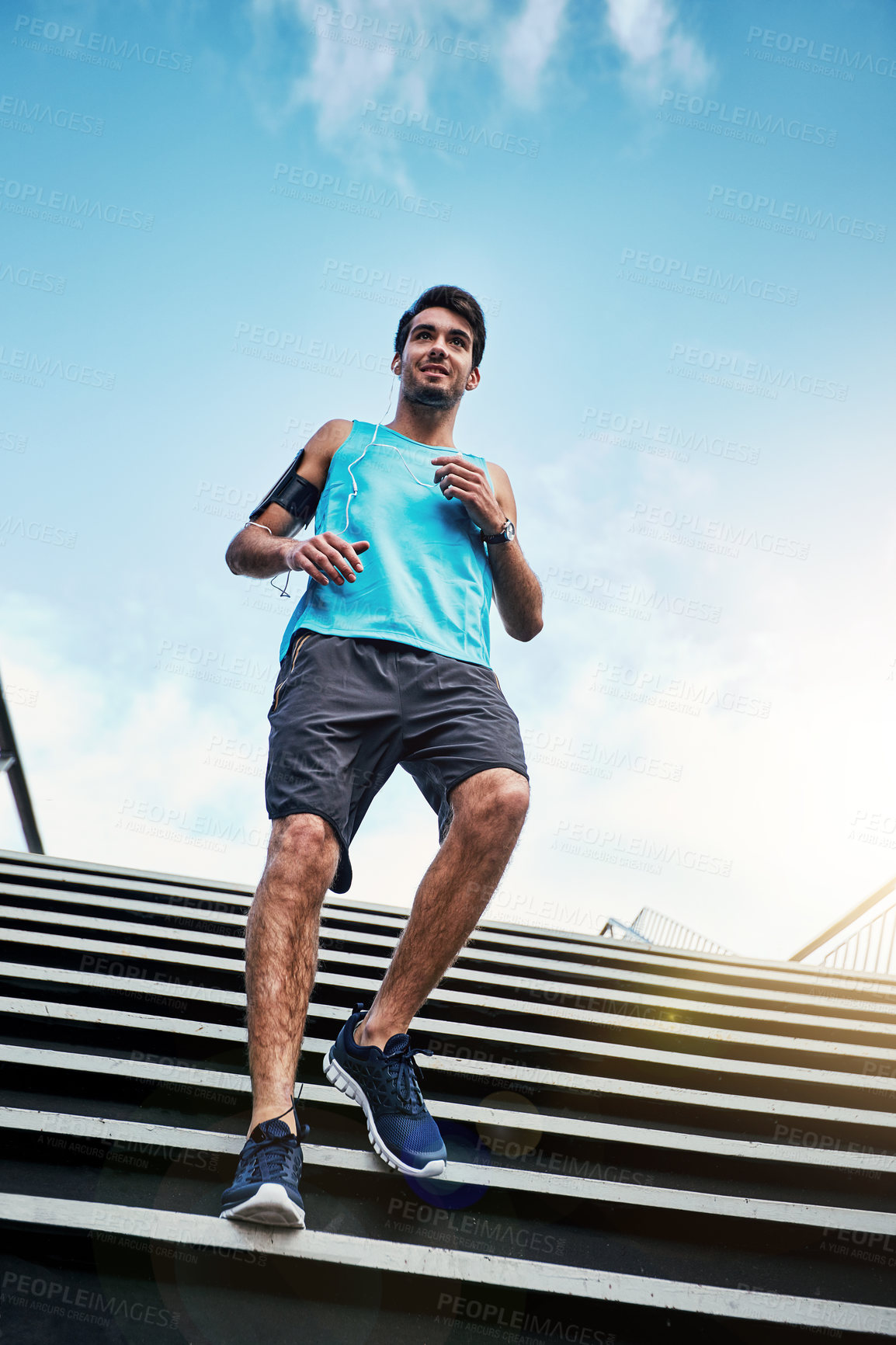 Buy stock photo Low angle shot of a handsome young man working out in the city