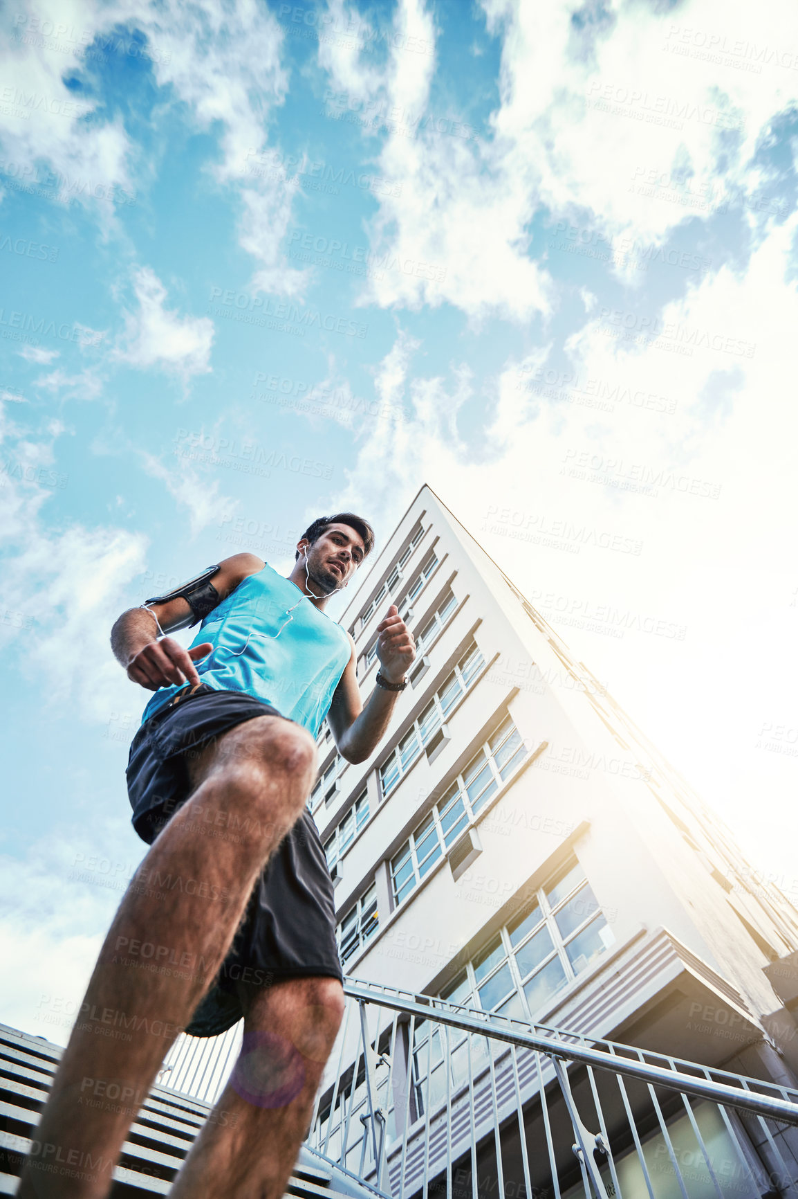 Buy stock photo Low angle shot of a handsome young man working out in the city