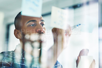 Buy stock photo Cropped shot of a handsome young businessman working on a glass wipe board