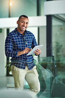 Buy stock photo Cropped portrait of a handsome young businessman using his tablet in the office