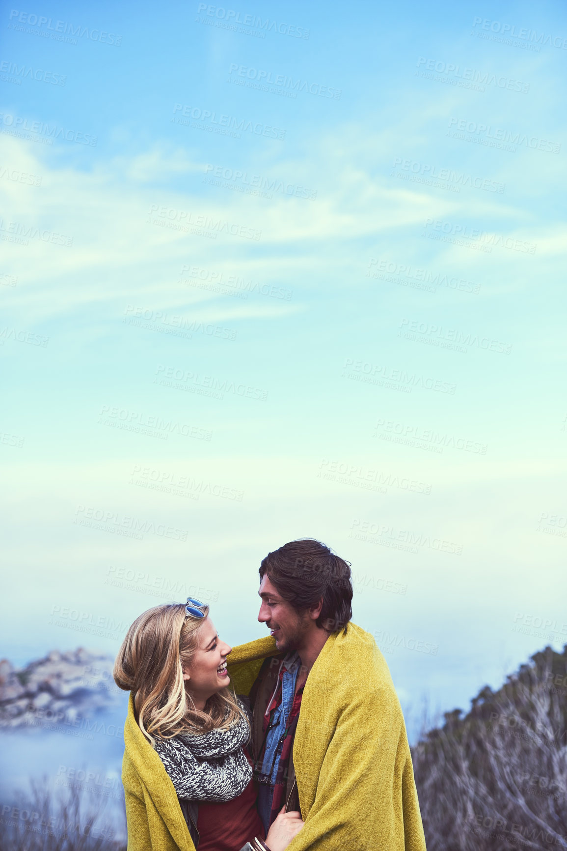 Buy stock photo Shot of an affectionate young couple enjoying a hike in the mountains