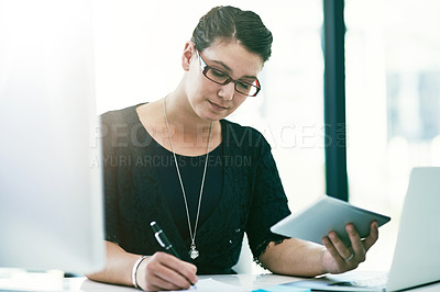 Buy stock photo Shot of a young businesswoman working at her desk in an office