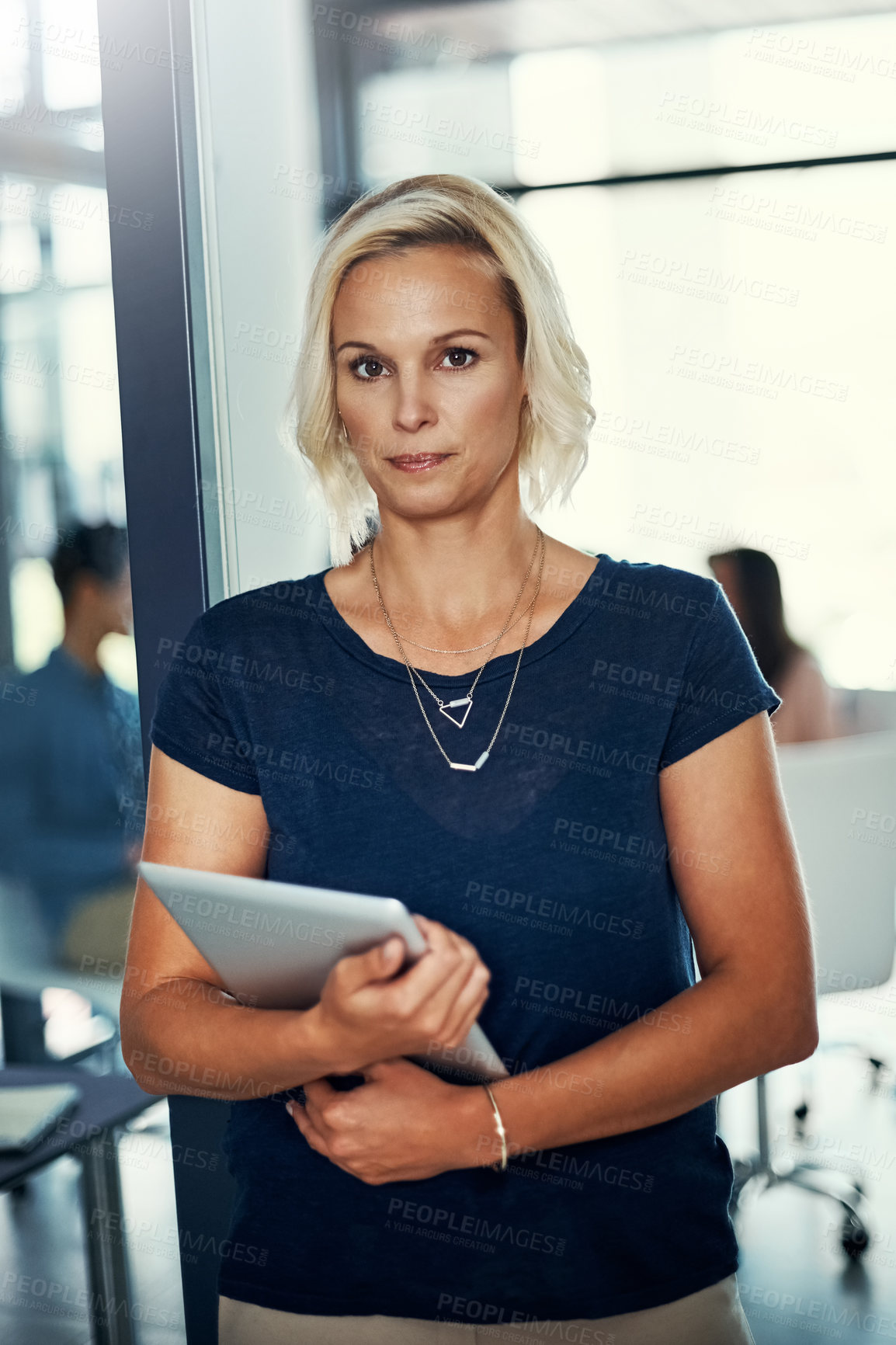 Buy stock photo Portrait of a confident young businesswoman using a digital tablet in an office