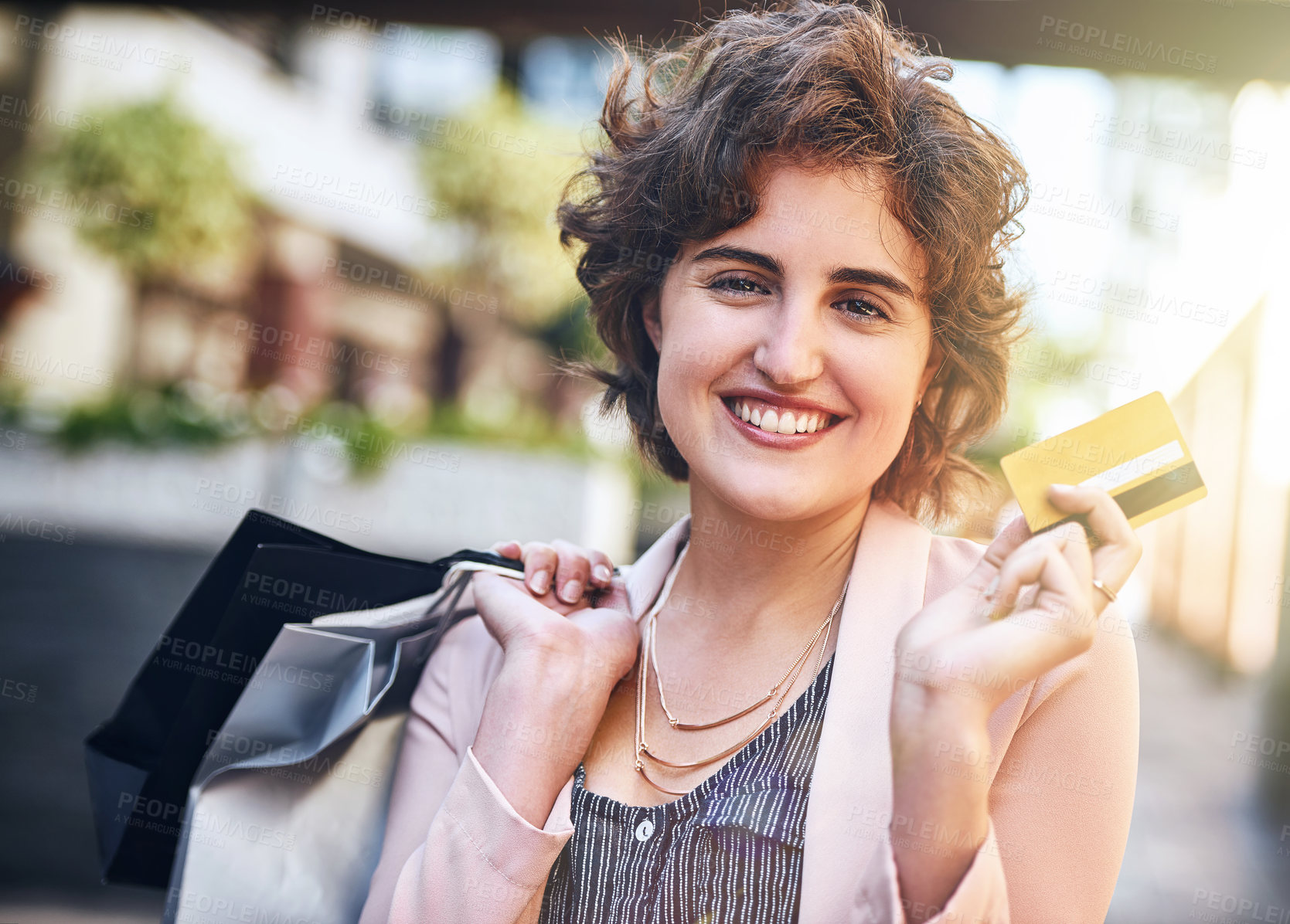 Buy stock photo Shot of a woman holding up her credit card while out shopping