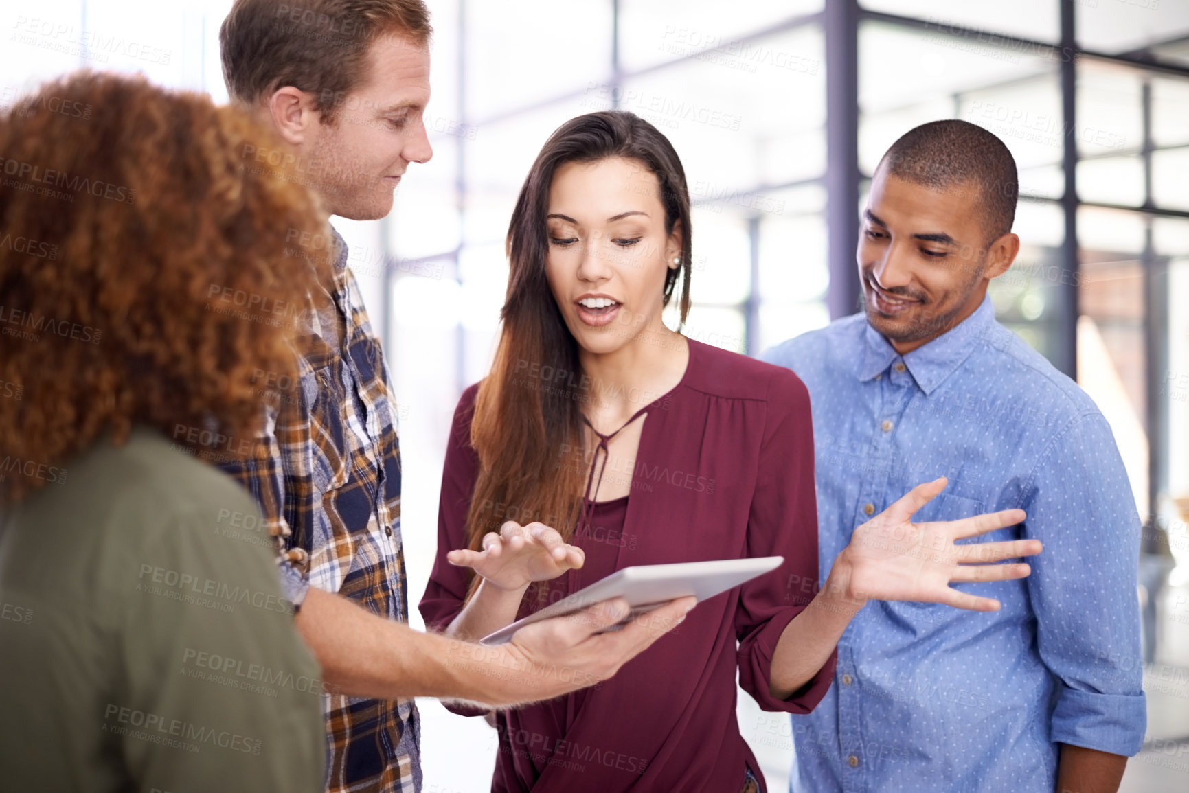 Buy stock photo Cropped shot of a team of designers working together on a digital tablet in an office