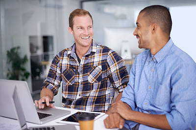 Buy stock photo Cropped shot of two young designers working together on a laptop in an office