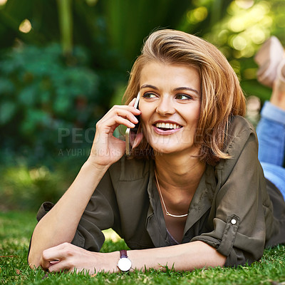 Buy stock photo Shot of an attractive young woman talking on her cellphone outside