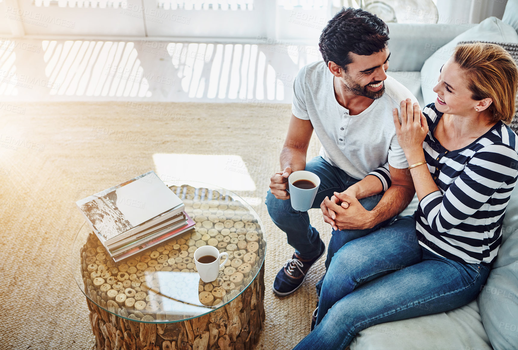 Buy stock photo High angle shot of an affectionate young couple having coffee together at home