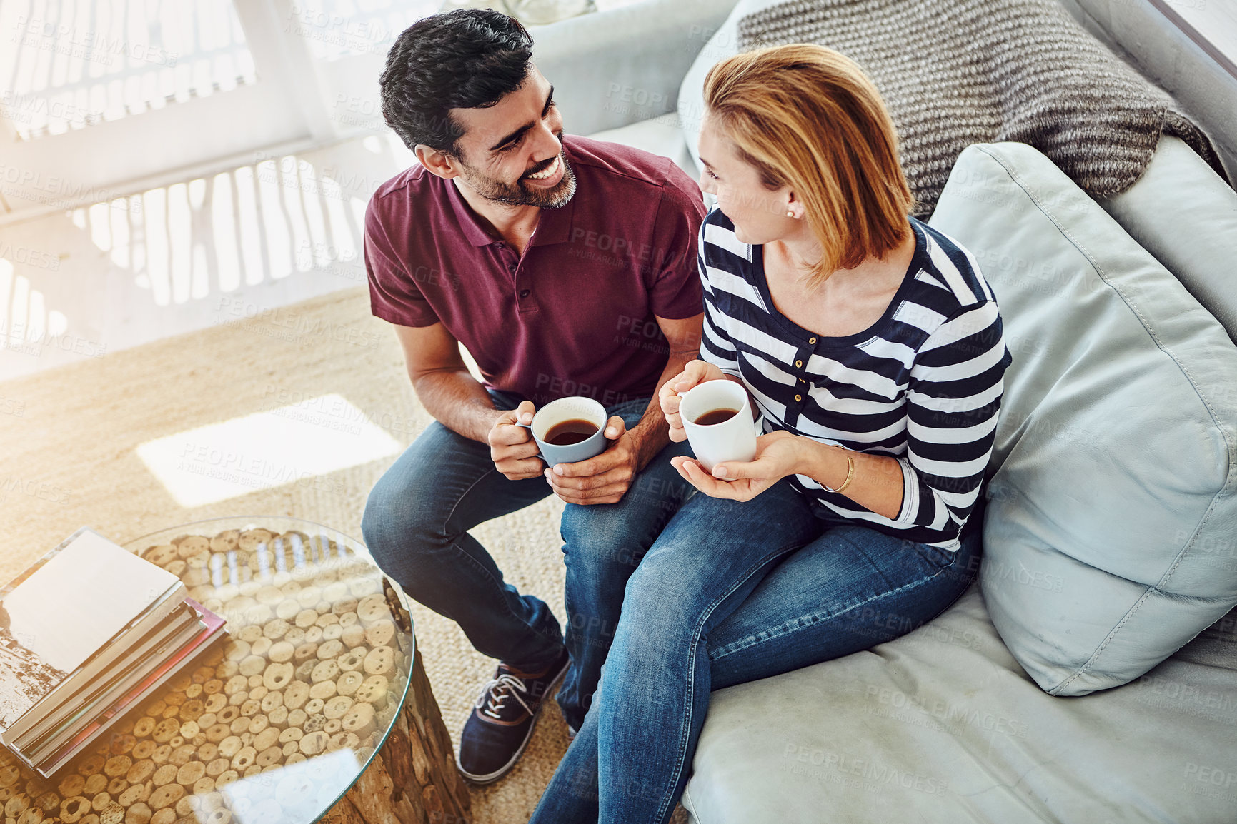 Buy stock photo High angle shot of an affectionate young couple having coffee together at home