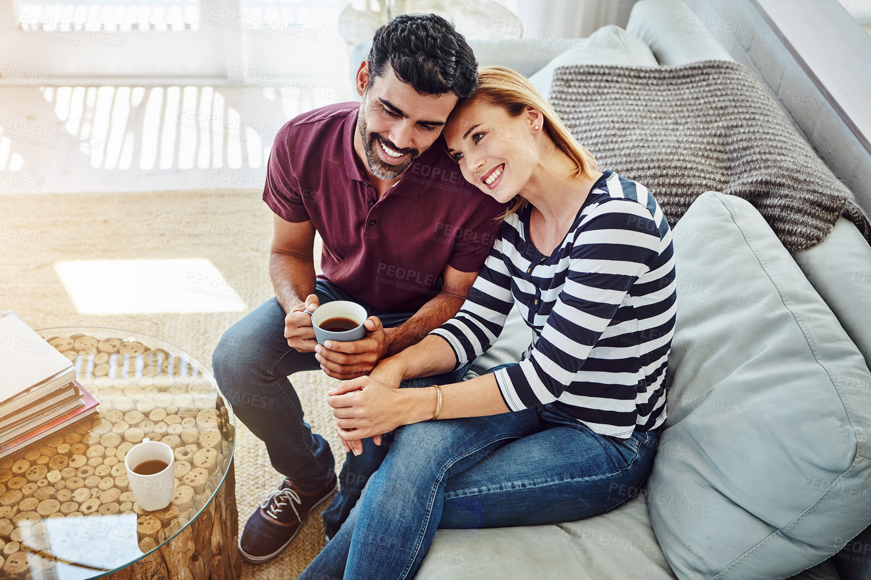 Buy stock photo High angle shot of an affectionate young couple having coffee together at home