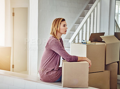 Buy stock photo Shot of a woman looking thoughtful while moving house