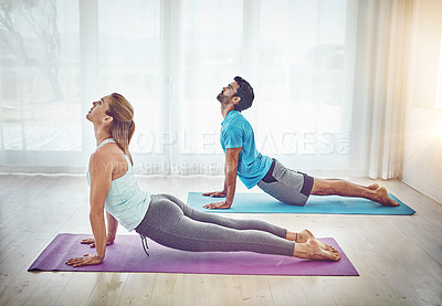 Buy stock photo Shot of a couple practising yoga at home