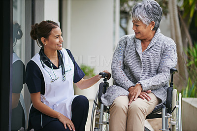 Buy stock photo Shot of a senior woman in a wheelchair being for for by a nurse at a retirement home