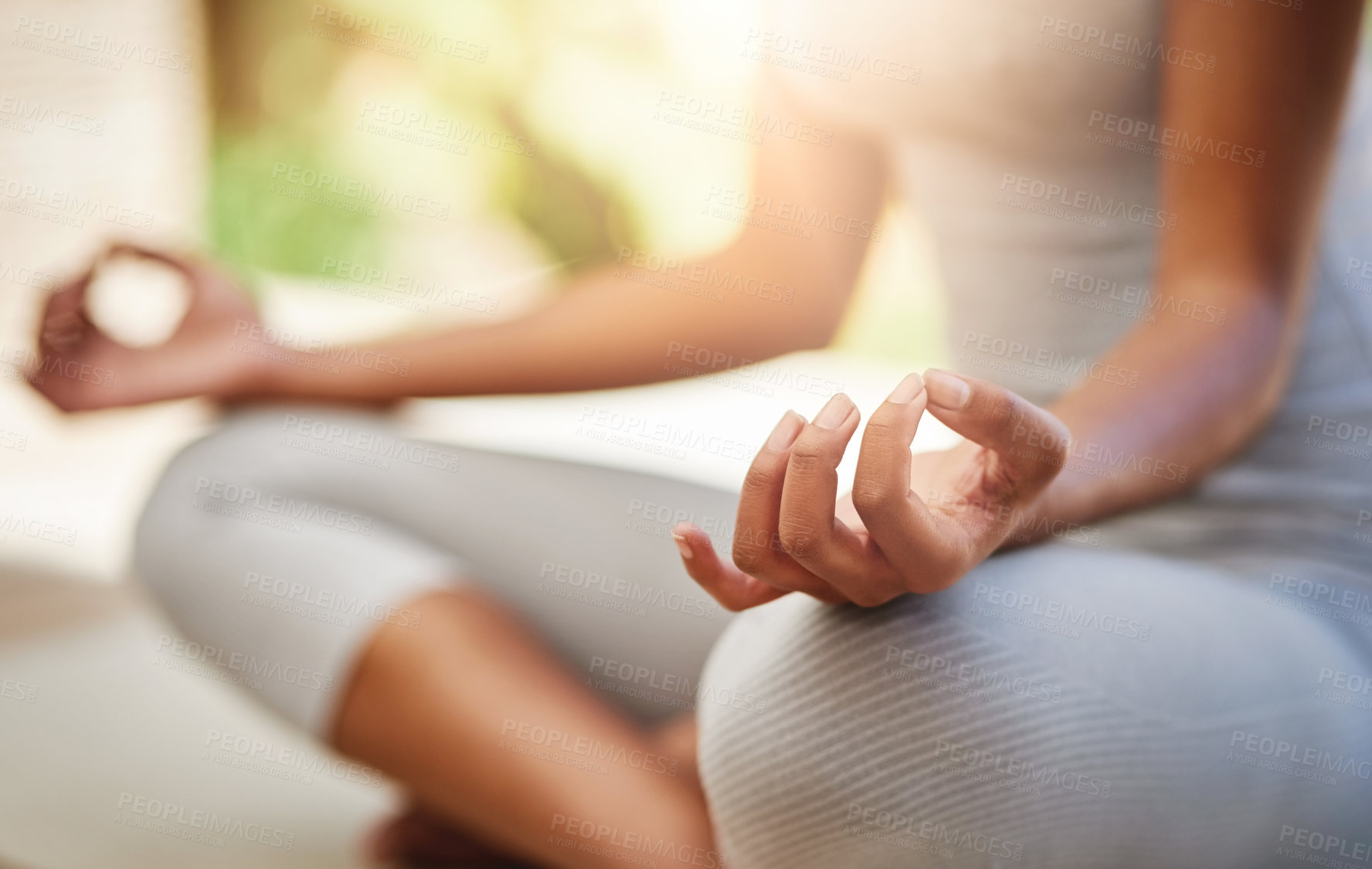 Buy stock photo Cropped shot of a sporty young woman practicing yoga outdoors