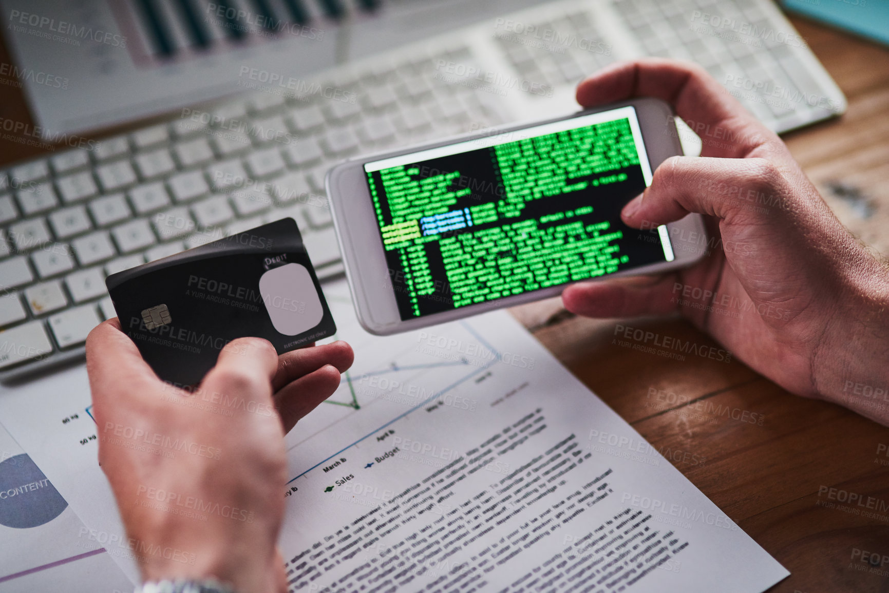 Buy stock photo Shot of an unidentifiable programmer holding his credit card while programming on his smartphone